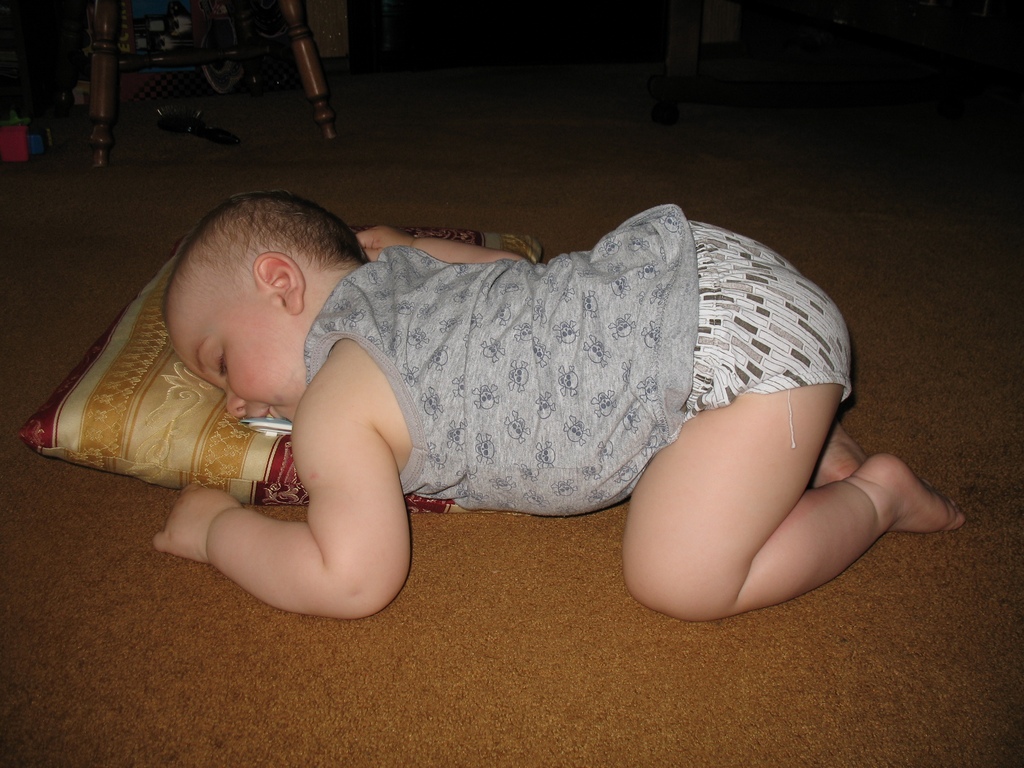 Почему дети поджимают ноги. Ребёнок спящий на животтке.